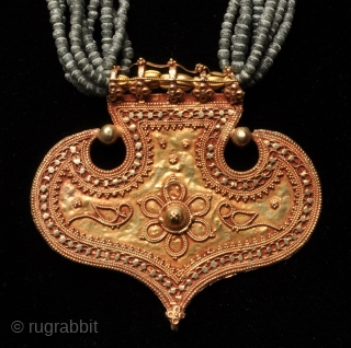 Gujarat gold pendant with glass beads
A golden pendant in the shape of an arrow head.
Fine granulation work
Was worn by the men and women of the Rabari tribe.      