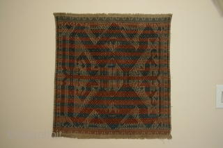 Ceremonial cloth ( tampan), Sumatra, Indonesia, cotton with supplemental weft patterning, 19th century, 27 x 29 inches.
The alternating bands of red and blue that cover the design is quite unusual.   