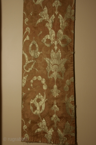 Silk brocade fabric panel with metalic gold thread, of a type now called "bizarre", England or France, circa 1680-1720, 15 x 40 inches, intact selvedge on one long side.Condition very good with  ...