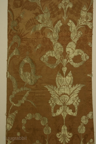 Silk brocade fabric panel with metalic gold thread, of a type now called "bizarre", England or France, circa 1680-1720, 15 x 40 inches, intact selvedge on one long side.Condition very good with  ...