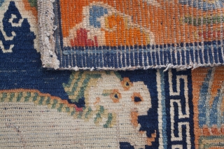 Charming Tibetan sitting rug depicting a snow lion. Dragon border. Lovely animals with great features. Typical signs of wear for a saddle top rug. Circa 1920. 70*57cm.      