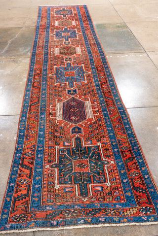Antique Persian Heriz Runner, circa 1910. Bold geometric medallions in deep red and indigo with ivory accents, framed by a classic angular Heriz border. Strong village weave, ideal for a long hallway  ...