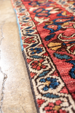 Antique Persian Bakhtiari Rug, circa 1920. Featuring a bold diamond medallion on a rich red field with indigo and ivory accents, framed by a lively floral border. Strong tribal character with vibrant, ...