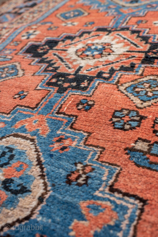 Antique Persian Heriz Rug, circa 1910. Featuring geometric medallions on a warm coral field with soft blue and ivory accents, framed by a bold tribal border. Classic Northwest Persian village design with  ...
