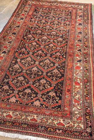 Antique Persian Malayer Rug, circa 1910. Featuring an allover lattice design on a dark ground with red and ivory accents, framed by multiple detailed borders. Finely drawn village weaving with elegant, rhythmic ...