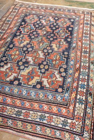 Antique Persian Kurdish Rug, circa 1920. Featuring an allover geometric medallion pattern on a deep indigo field with soft coral and ivory accents, framed by multiple tribal borders. Bold village weaving with  ...
