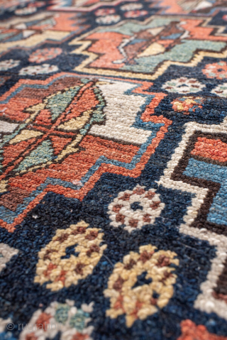 Antique Persian Kurdish Rug, circa 1920. Featuring an allover geometric medallion pattern on a deep indigo field with soft coral and ivory accents, framed by multiple tribal borders. Bold village weaving with ...