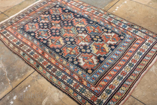 Antique Persian Kurdish Rug, circa 1920. Featuring an allover geometric medallion pattern on a deep indigo field with soft coral and ivory accents, framed by multiple tribal borders. Bold village weaving with  ...