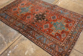 Antique Persian Heriz Rug, circa 1910. Featuring bold geometric medallions on a warm rust field with turquoise and ivory accents, framed by a classic angular Heriz border. Strong village weaving with lively  ...