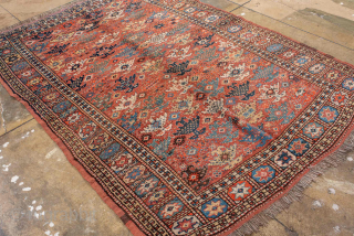 Antique Kurdish Rug, circa 1900. Featuring an allover tribal pattern on a warm rust field with soft blue and ivory accents, framed by a geometric star border. Lively village weaving with bold  ...