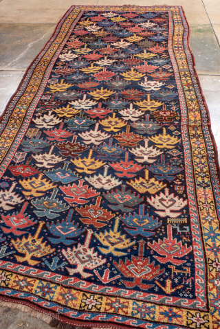 Antique Persian Kurdish Runner, circa 1910. Featuring an allover stylized boteh motif on a dark field with vibrant red, blue, and ivory accents, framed by simple geometric borders. Bold tribal design with  ...