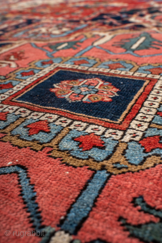 Antique Persian Heriz Carpet, circa 1900. Featuring a bold geometric medallion on a vibrant red field with deep indigo and ivory accents, framed by a classic Heriz border. Strong Northwest Persian design  ...