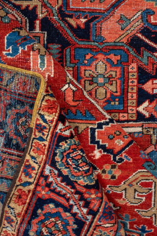 Antique Persian Heriz Carpet, circa 1900. Featuring a bold geometric medallion on a vibrant red field with deep indigo and ivory accents, framed by a classic Heriz border. Strong Northwest Persian design  ...
