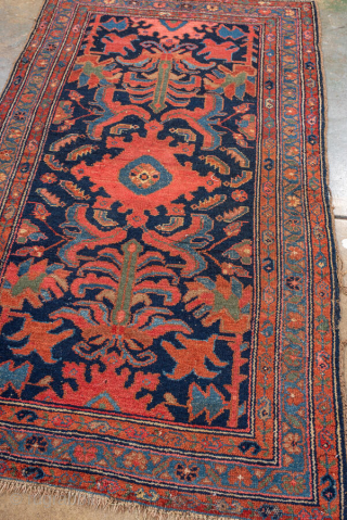 Antique Persian Malayer Rug, circa 1920. Featuring a bold, stylized medallion and angular floral motifs on a deep navy field with warm rust and soft blue accents, framed by a classic Heriz-inspired  ...