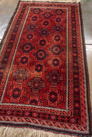 Antique Belouch Rug, circa 1920. Featuring repeating geometric guls on a rich red field with deep navy accents, framed by multiple narrow tribal borders. Compact, finely drawn design with classic Baluch character.

Item  ...