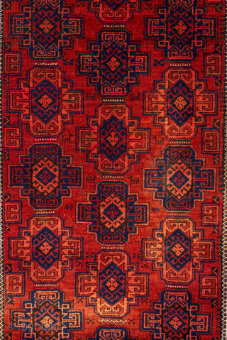 Antique Belouch Rug, circa 1920. Featuring repeating geometric guls on a rich red field with deep navy accents, framed by multiple narrow tribal borders. Compact, finely drawn design with classic Baluch character.

Item  ...
