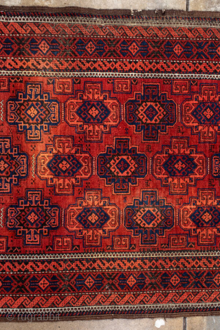 Antique Belouch Rug, circa 1920. Featuring repeating geometric guls on a rich red field with deep navy accents, framed by multiple narrow tribal borders. Compact, finely drawn design with classic Baluch character.

Item  ...
