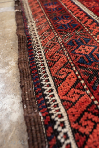 Antique Belouch Rug, circa 1920. Featuring repeating geometric guls on a rich red field with deep navy accents, framed by multiple narrow tribal borders. Compact, finely drawn design with classic Baluch character.

Item  ...