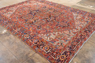 Antique Persian Heriz Rug, circa 1900. Featuring a striking geometric medallion on a vivid rust-red field with deep navy and ivory accents, framed by a bold angular border characteristic of Northwest Persian ...