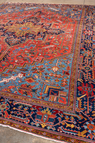 Antique Persian Heriz Rug, Circa 1910. Features a bold geometric medallion design rendered in vibrant shades of red, navy, sky blue, and camel. Commanding scale, rich colors, and durable construction make ...