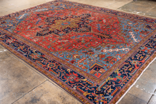 Antique Persian Heriz Rug, Circa 1910. Features a bold geometric medallion design rendered in vibrant shades of red, navy, sky blue, and camel. Commanding scale, rich colors, and durable construction make ...