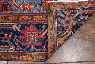 Antique Persian Heriz Rug, Circa 1910. Features a bold geometric medallion design rendered in vibrant shades of red, navy, sky blue, and camel. Commanding scale, rich colors, and durable construction make ...