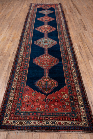 Antique Persian Bidjar Runner, Circa 1900. Showcases a dramatic chain of geometric lozenge medallions woven across a deep midnight blue field framed by richly detailed terracotta borders.

3'7" x 15'0"

Item No: 74360  