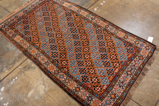 Antique Persian Kurdish Rug, Circa 1900. Vibrant allover lattice of geometric rosettes woven across a warm camel field framed by a crisp ivory floral border.
3'0" x 5'6"
Item No: 99752