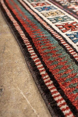 Antique Persian Kurdish Runner, Circa 1900. Succession of colorful geometric medallions surrounded by small tribal and figural motifs on a deep brown field.

3'6" x 12'5"

Item No: 99582      