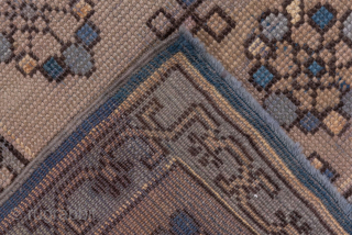 This antique Oushak rug features a rare and striking blue field with an elegant central medallion design. The geometric latticework across the field creates depth and texture, while the soft ivory border,  ...