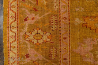 This antique Oushak rug glows with rich, warm tones of golden saffron, soft apricot, and muted blush. Its geometric medallion-and-corner design is framed by a beautifully drawn border, giving the rug a  ...
