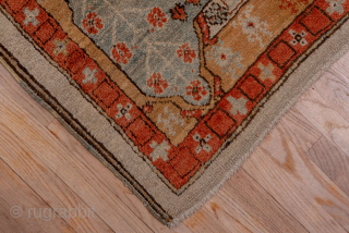 This antique Oushak rug, woven circa 1900, features a captivating Tree of Life design with stylized floral and botanical motifs cascading across an ivory field. The delicate, painterly pattern is framed by  ...