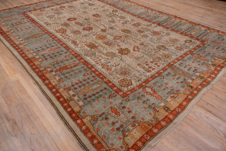 This antique Oushak rug, woven circa 1900, features a captivating Tree of Life design with stylized floral and botanical motifs cascading across an ivory field. The delicate, painterly pattern is framed by  ...