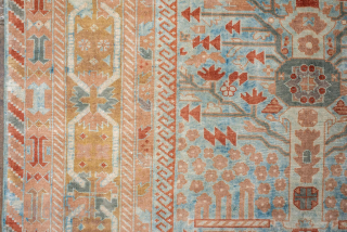 This antique Sivas rug, woven circa 1920, showcases a striking botanical garden design with stylized floral motifs and tree forms arranged in a symmetrical lattice pattern. The soft blue field is accented  ...
