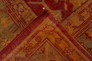 This antique Turkish Oushak rug, woven circa 1900, features a striking deep red field adorned with soft gold and muted blue floral motifs. The wide, decorative border frames the design beautifully, showcasing  ...