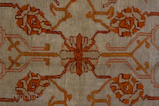 This antique Oushak rug, woven circa 1900 in Western Anatolia, showcases the region’s signature large-scale, open design with striking color contrasts. The ivory ground is adorned with an allover floral lattice rendered  ...