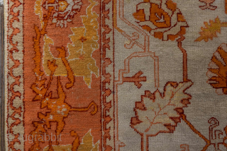 This antique Oushak rug, woven circa 1900 in Western Anatolia, showcases the region’s signature large-scale, open design with striking color contrasts. The ivory ground is adorned with an allover floral lattice rendered  ...