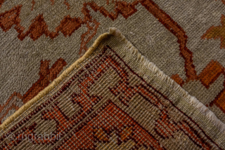 This antique Oushak rug, woven circa 1900 in Western Anatolia, showcases the region’s signature large-scale, open design with striking color contrasts. The ivory ground is adorned with an allover floral lattice rendered  ...