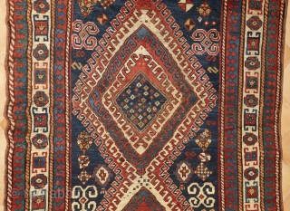 Beautiful, antique, tribal Kazak from Moghan area measuring 236x114cm with outstanding colours. On a blue ground there are two multi-hooked and multi colour medallions containing archetypic symbols of fertility and good luck.  ...