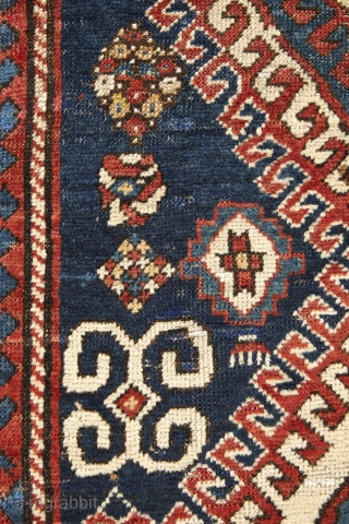 Beautiful, antique, tribal Kazak from Moghan area measuring 236x114cm with outstanding colours. On a blue ground there are two multi-hooked and multi colour medallions containing archetypic symbols of fertility and good luck.  ...