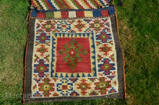 NW Persian flat woven khorjin. 57" X 25". Early 20th C.  Wool. Dovetailed tapestry. Bright stable cheerful colors. Plain woven back in natural undyed black wool. Lovingly kept in almost perfect  ...