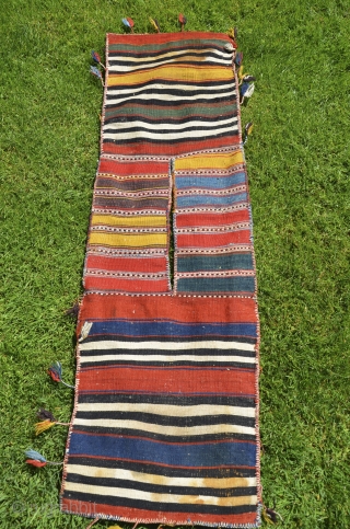 West Anatolian pile heybe, Kilaz, 3'7" X 1'4". Wool. Circa 1900. Bright natural dyes. Faces in perfect condition with full pile and original pompom tassels. Striped back with a few stains. Dowry  ...