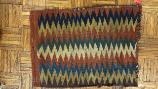 Shasavan Kilim Bagface -zig-zags-, ca.1870; 1’8” x 2’0”/ 51 x 62 cm. rows of zig-zag stripes in rust red, indigo, green, ivory, teal, goldenrod, and aubergine. Slight traces of fold lines.
  