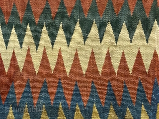 Shasavan Kilim Bagface -zig-zags-, ca.1870; 1’8” x 2’0”/ 51 x 62 cm. rows of zig-zag stripes in rust red, indigo, green, ivory, teal, goldenrod, and aubergine. Slight traces of fold lines.
  
