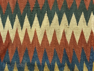 Shasavan Kilim Bagface -zig-zags-, ca.1870; 1’8” x 2’0”/ 51 x 62 cm. rows of zig-zag stripes in rust red, indigo, green, ivory, teal, goldenrod, and aubergine. Slight traces of fold lines.
  