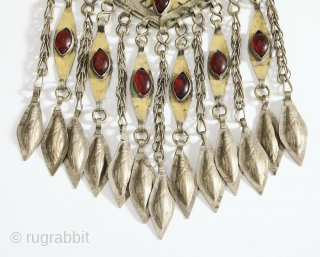 Tekke Turkmen robe closure pendant, late 19th or early 20th century. Lozenge form with piercing and engraving as well as chasing of gold over silver, with cabochon set glass, suspending chains with  ...