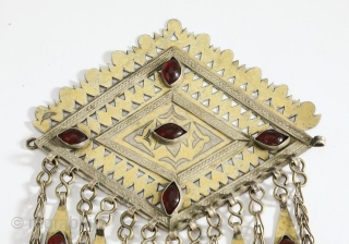 Tekke Turkmen robe closure pendant, late 19th or early 20th century. Lozenge form with piercing and engraving as well as chasing of gold over silver, with cabochon set glass, suspending chains with  ...