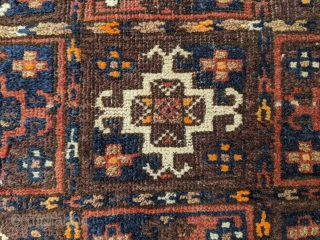 Old Baluch saddle cover. 2'10" x 3'5". Small silk highlights, overall good pile. Original sides except the bottom right corner. One small area of moth damage photographed.

Cheers.      