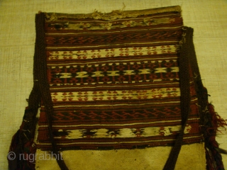 2 pieces, Late 19th/Early 20th Century Tekke Turkmen Saddle Bags (Wool-on-Cotton). with unstitched backs. Can do with some cleaning.
Dimensions: Bag Fronts --- Lengths: Approx.34cm-38cm. Widths: Approx.38cm-39cm. Bag Fringes: Approx.28cm 
Side-Tassels: Approx.42cm-49cm length  ...