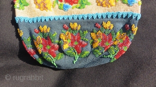 Exquisite micro beading to this purse made over 100 years ago, probably in France.Tiny beads, arranged to depict a wonderful assortment of flowers: roses, pansies, marigolds and Morning Glory in a broad  ...